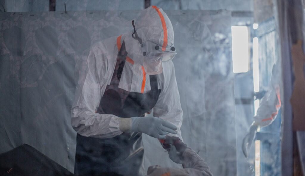 A health worker in full protective gear prepares to enter a treatment zone in Bunia, DRC. The Congolese government has integrated health and community security forces to create safe operating corridors for frontline medical personnel trying to halt transmission rates. (Photo: File/News Agency) 1